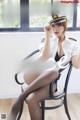 A woman in a police uniform sitting on a chair.