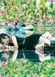 A woman laying on the ground in front of flowers.