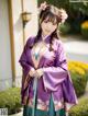 A woman in a purple and green hanbok posing for a picture.