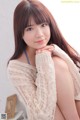 A woman in a white sweater posing for a picture.