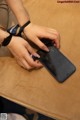 A person sitting at a table using a cell phone.