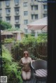 A naked woman sitting on a patio next to a chair.