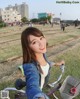 A woman sitting on a bike in a park.